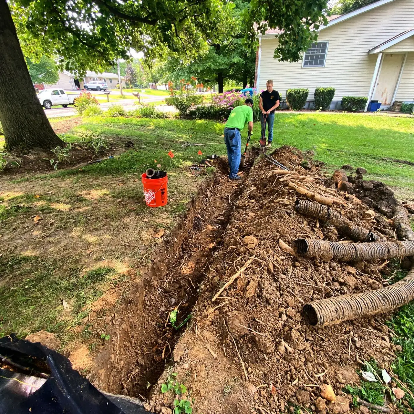Sugarloaf crew digging a drainage line across a front yard